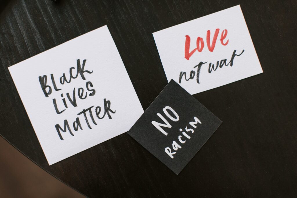 black lives matter sign, no racism sign, and love not war sign