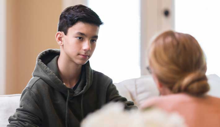 young boy with serious expression discussing mental health illnesses