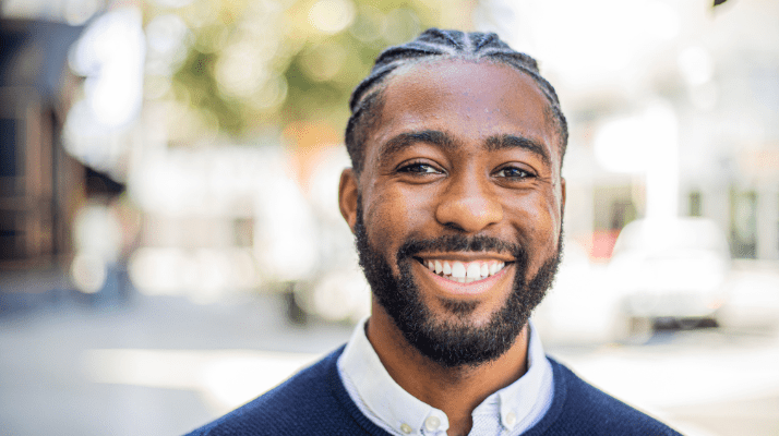 Black male standing outside smiling